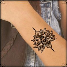 a woman's arm with a black and white tattoo design on the wrist,