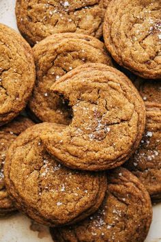 a pile of cookies sitting on top of a white plate covered in powdered sugar