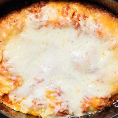 a casserole dish with cheese and sauce in it