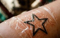 a person with a star tattoo on their arm, wrapped up in plastic wrappers