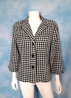 "A 3-button fitted jacket/blazer in a soft woven classic black and white houndstooth. Wide, short lapel and bracelet length sleeves. No pockets. Padded shoulders. Slight pilling here and there but otherwise good condition. Decade: 1990s Label: Dressbarn, Made in USA of imported fabric Material: acrylic with polyester lining Closure: 3 buttons Vintage Condition: very good to excellent (From a pet and smoke free home) Measurements are taken flat and doubled where necessary. This is marked size XL. Neck: 27\" Shoulder span: 18\" Sleeve length: 18.5\" Upper arm: 16\" Cuff: 11\" Bust: 44\" Waist: 38\" Bottom opening: 47\" Length: 24\" NO RETURNS - ALL SALES ARE FINAL. Please check the measurements I've given, and measure yourself or a garment that fits you well to compare, before committing to Fitted Semi-formal Outerwear With Houndstooth Pattern, Spring Fitted Houndstooth Blazer, Fitted Houndstooth Blazer For Spring, Casual Fitted Houndstooth Blazer, Black Houndstooth Blazer For Spring, Formal Long Sleeve Lined Blazer, Fitted Houndstooth Button-up Outerwear, Classic Houndstooth Outerwear For Spring, Plaid Formal Outerwear For Spring