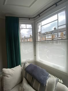 a white couch sitting in front of two windows