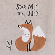 a white towel with a brown fox on it's side and the words stay wild my child written in black