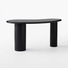 an oval table with black legs and a curved top is shown in front of a white background