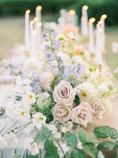 a table topped with lots of white and blue flowers