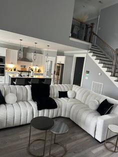 a living room filled with furniture next to a staircase