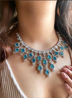 Add a touch of glamour and sophistication with this high quality  necklace set in beautiful aqua blue stones. The stones in this set bling and look close to the real thing. This set is sure to make heads turn!  It features an adjustable necklace and a pair of earrings. It can be paired perfectly with both ethnic and western outfits.  In case of any queries, please feel free to reach out. Happy shopping! Necklace weight- 70 gms   Length- 16"  Adjustable length with a metal chain at the back Each Prom Jewellery, Blue Stones, Prom Jewelry, Wedding Bridal Jewellery, Wedding Jewellery Necklace, Silver Spring, American Diamond, Adjustable Necklace, Western Outfits