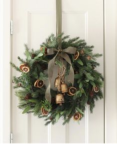 a wreath with bells hanging on the front door