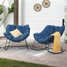 two blue chairs sitting on top of a patio