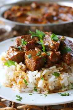 a white plate topped with rice and meat