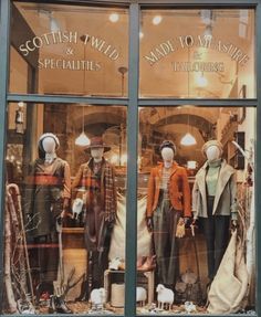 the front window of a clothing store with mannequins and hats on display