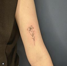 a woman's arm with a single flower tattoo on the left side of her arm