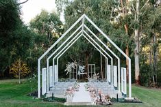 an outdoor ceremony setup with white chairs and flowers