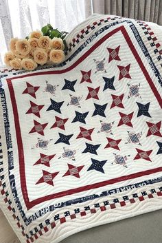 a red, white and blue quilt with stars on it