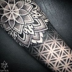 an intricate tattoo design on the forearm and arm, with white ink in black colors