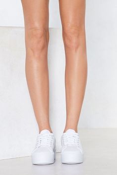 a woman's legs wearing white tennis shoes