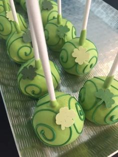 green cake pops with shamrock decorations on them