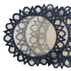 an oval doily with black lace on it and white fabric in the center,