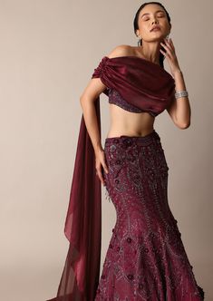 Featuring our whimsical wine jeweled lehenga paired with a stylized blouse that is a beautiful amalgamation of opulence and charm. Accented with sparkly jewels this fish cut silhouette wraps your curves with elegance and grace. The stylized blouse elevated with feminine trail draping and wide neck fit complete this grandeur effortless look. Dry clean only if required. Slight variation in color is possible due to digital photography. Modern Indian Wedding Guest Outfit, Formal Lehenga With Sequins In Traditional Drape, Formal Lehenga With Sequins And Traditional Drape, Festive Embellished Formal Lehenga, Formal Hand Embellished Lehenga With Traditional Drape, Embellished Party Wear Choli For Formal Occasions, Bollywood Style Embellished Lehenga For Formal Occasions, Formal Embellished Party Wear Choli, Glamorous Formal Lehenga With Traditional Drape