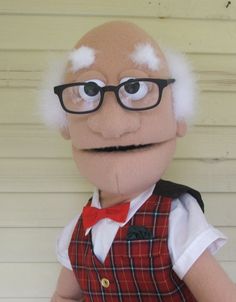 an old man with glasses and a red vest is standing in front of a house