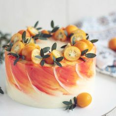 a cake with oranges and leaves on it