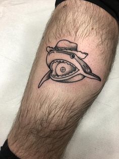 a man with a hat and eye tattoo on his leg