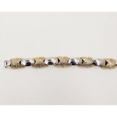 This is part of Chairish’s Costume Jewelry assortment.  1970s rhodium plated with textured goldtone x connectors bracelet with fold over clasp. Marked "Napier." Measures: 7 1/2 inches long by 5/8 inches wide. Condition: Very good; some minor goldtone, some wear/darkening/wear to back. The matching necklace is also available.  Please reference the measurements noted in the description above for the best approximate dimensions. Please reach out to the seller under "Ask the Seller" for specific que Formal Gold-tone Metal Bracelets, Formal Gold-tone Metal Bracelet, Metal Bracelets With Polished Finish For Anniversary, White Gold Formal Bracelet, Vintage White Gold Metal Chain Bracelet, Retro Metal Bracelet For Formal Occasions, Retro Metal Bracelets For Formal Occasions, Gold Retro Bracelets For Formal Occasions, Formal Metallic Metal Jewelry