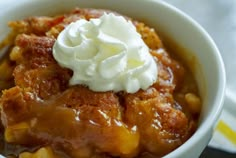 a close up of a bowl of food with whipped cream on top