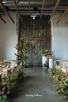 an indoor wedding ceremony with flowers and greenery