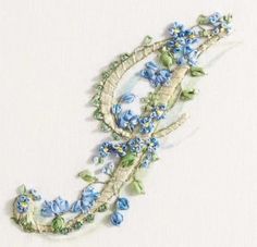 a blue flowered necklace with green leaves and flowers hanging from it's side