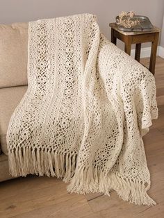 a white crocheted afghan draped over a couch