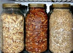 three jars filled with different types of food in a refrigerator next to a wire rack