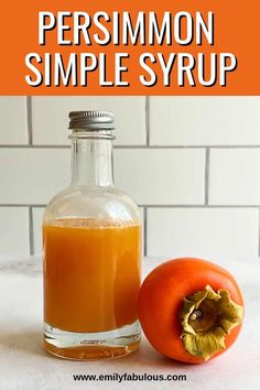 a glass bottle filled with liquid next to an orange on top of a white counter