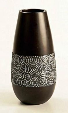 a black vase with white swirls on it