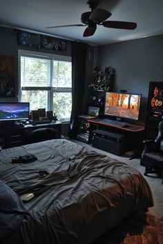 a bedroom with a bed, desk and two laptops on the windows sill