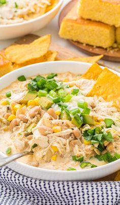 a white bowl filled with chicken and tortilla soup next to cornbreads