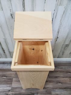 a wooden box sitting on top of a hard wood floor next to a white wall