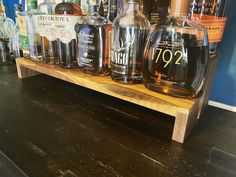 several bottles of liquor on a wooden shelf