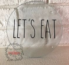 a metal sign that says let's eat on the side of a brick wall