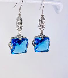 Simulated Swiss Blue Topaz Earrings  Long Vic Design#E77 Custom Made These are Victorian reproduction estate earrings in sterling silver set with flawless high quality simulated swiss blue gemstones. Each stunning blue gemstone is 15mm long (9/16th") and 15mm wide. The earrings are 2" long. Notice the beautiful floral setting. These lovely earrings were designed from an antique Victorian floral ring.   Suggested Retail $199+.  Shop more earrings here! https://www.etsy.com/shop/SilverEmbraceJewel Blue Sterling Silver Earrings For Evening, Nickel-free Blue Crystal Earrings For Formal Occasions, Blue Filigree Dangle Jewelry, Blue Crystal Earrings With Ear Wire For Formal Occasions, Blue Earrings For Evening With Pierced Ears, Handmade Blue Evening Earrings, Victorian Filigree, Order Design, Blue Topaz Earrings