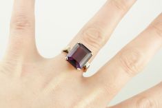 Classic elegance! We've completely restored this vintage, yellow gold mounting and set it with a gorgeous new amethyst of the deepest shade of aubergine purple! The bold but simple style of this ring allow it to be worn for a variety of occasions, from a day to day signature piece to an eye-catching accessory for the finest gown. Metal: 14K Yellow Gold Gem: Amethyst 9.55 Carats Gem Measurements: 13.9 x 11.9 mm, Rectangle Emerald Cut Ring Size: 7.25 Marks: "JAM14K" Stamped on the inside band Emerald Cut Ring, Emerald Cut Rings, Pocket Watch Chain, Watch Chain, Day To Day, To Day, Vintage Yellow, Classic Elegance, Pearl Pendant