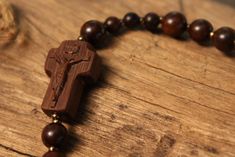 +.This is a rosary bracelet made of wood. The crucifix and the beads are constructed of wood. +.The wooden rosary is beneficial because you can feel the softness of the wood while praying. The more you contact wood, the more it takes on a natural brilliance. +.Surinamese ebony was used to make the crucifix. The light brown tone of Surinamese ebony is appealing. Surinamese ebony is so hard that it may be carved finely. It is carved over a long period of time rather than molded for a few minutes. Handmade Cross Rosary Bracelet For Blessing, Handmade Cross-shaped Rosary Bracelet For Blessing, Spiritual Cross Beaded Bracelets As Gift, Spiritual Cross Beaded Bracelets For A Gift, Spiritual Style Cross Beaded Bracelets For Gift, Spiritual Crucifix Rosary As Gift, Gift Rosary Bracelet With 8mm Beads And Crucifix, Handmade Brown Rosary Bracelet As Gift, Spiritual Brown Rosary Bracelet For Gift