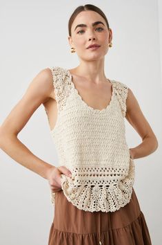 a woman wearing a crochet top and brown skirt