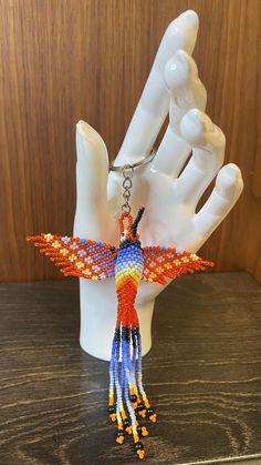 a beaded dragon charm hanging from a hand