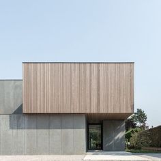 an exterior view of a concrete building with wood cladding