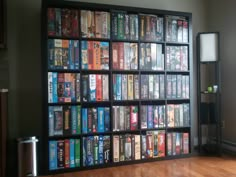 a book shelf filled with lots of books on top of a hard wood floor