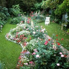 an aerial view of a garden with many flowers and trees in the back ground,