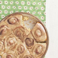 a bowl filled with food sitting on top of a green and white table cloth next to a spoon