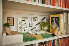 a bookshelf filled with lots of books next to a couch