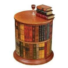 a wooden table topped with lots of books and a wine glass on top of it